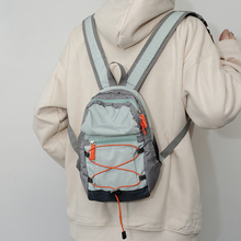 На свежем воздухе с двумя плечами, маленьким рюкзаком для альпинистов.